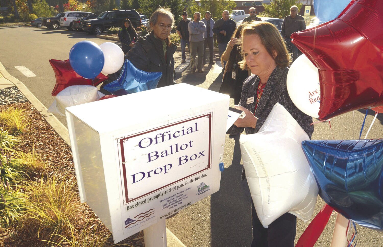 Thurston County Auditor Mary Hall officially unlocks a new ballot box installed outside the Nisqually Administration Building.